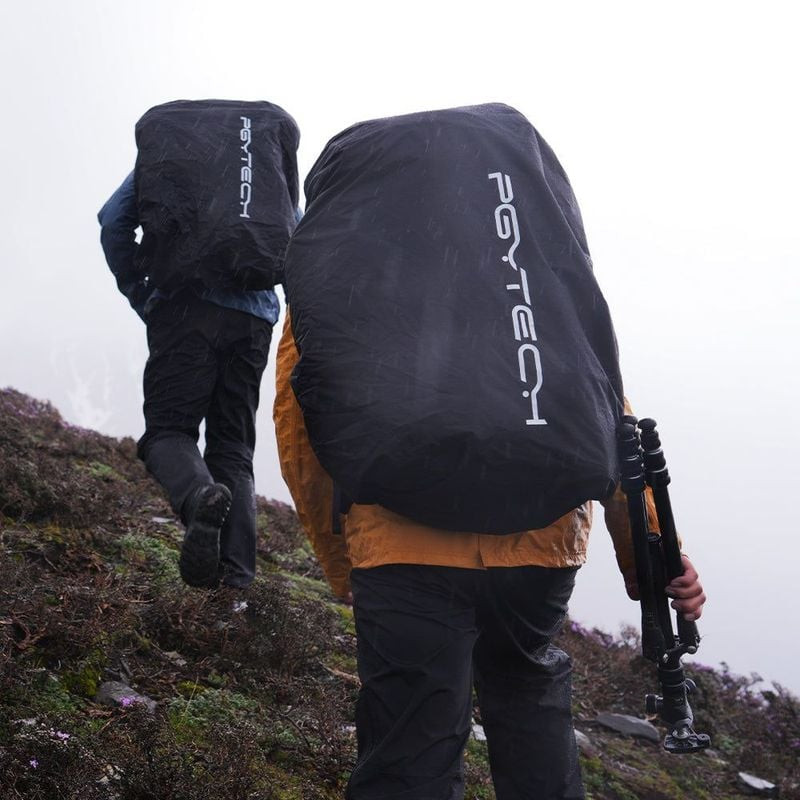 Deux randonneurs sous la pluie avec sacs PGYTECH OnePro Focux 25L Space Black protégés par housses, 