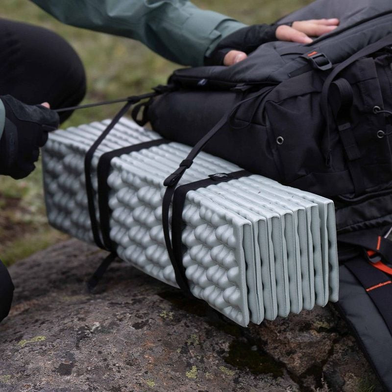 Gros plan sur le sac à dos PGYTECH OnePro Focux 25L avec tapis de mousse attaché par sangles sur ter