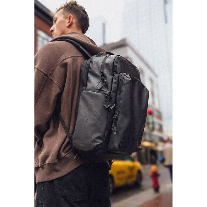 Personne portant le sac à dos WANDRD PRVKE Pocket 31L en environnement urbain près de bâtiments et t