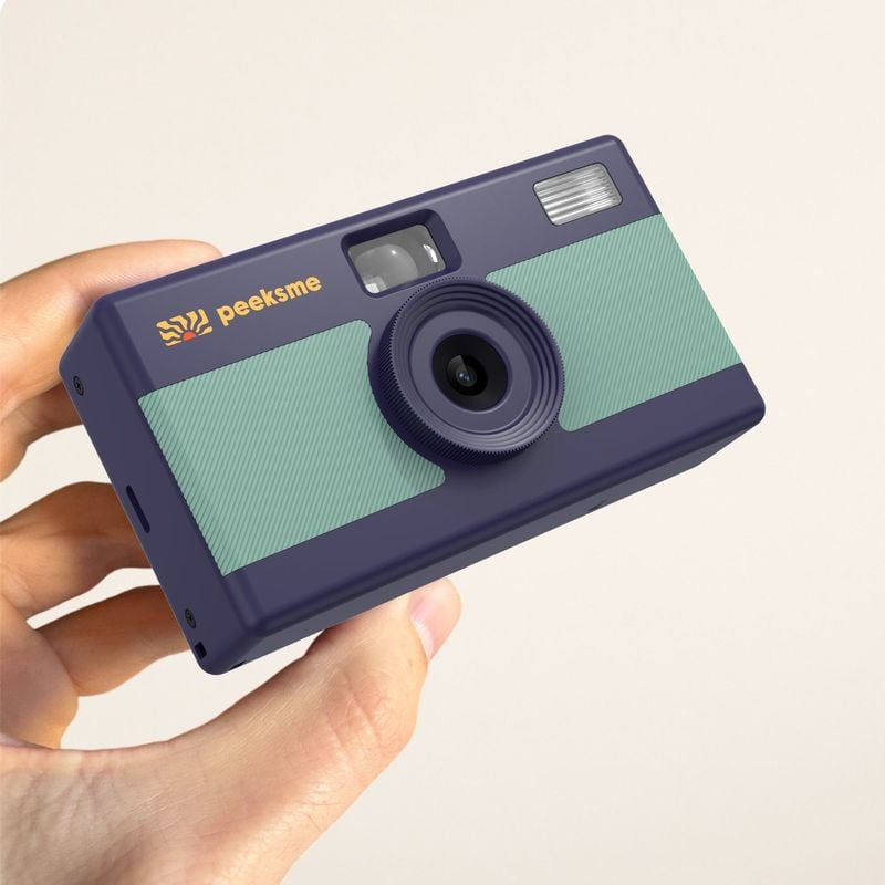 Homme souriant photographiant un paysage urbain avec le PEEKSME VERT APPAREIL PHOTO NUMERIQUE RETRO.