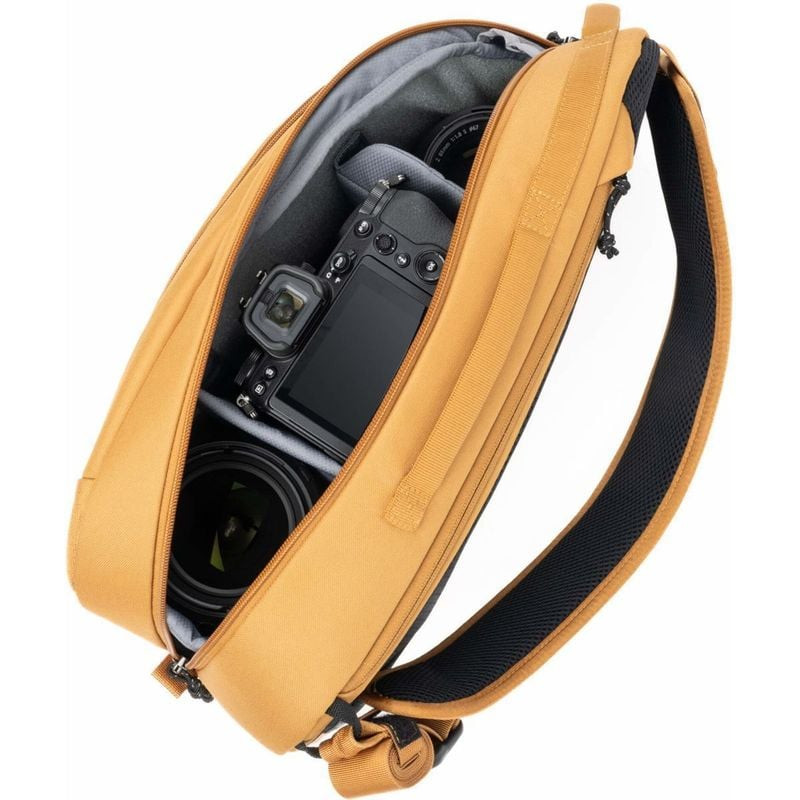 Sac sling Think Tank TurnStyle 11L Golden Hour ouvert dévoilant un appareil Nikon et des objectifs