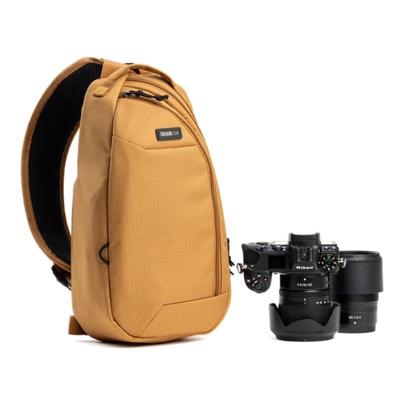 Photographe portant le sac THINK TANK TURNSTYLE 8L GOLDEN HOUR en extérieur, accès rapide au matérie