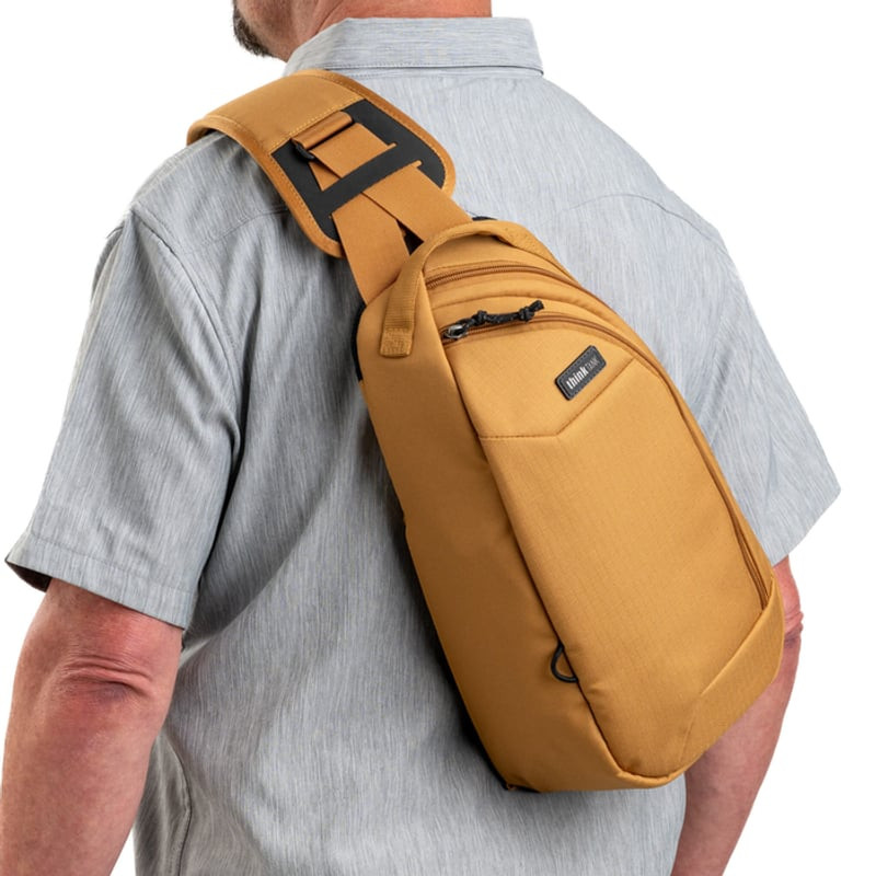 Photographe en action avec le sac THINK TANK TURNSTYLE 8L GOLDEN HOUR, accès rotatif rapide.