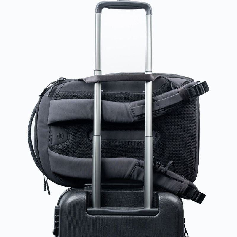 Panneau dorsal du sac à dos PGYTECH OneGo Lite 22L fixé à la poignée d'une valise à roulettes via sa