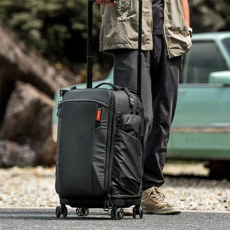 Sac à dos trolley PGYTECH Roller Camera Backpack noir debout en extérieur près d'une personne et d'u