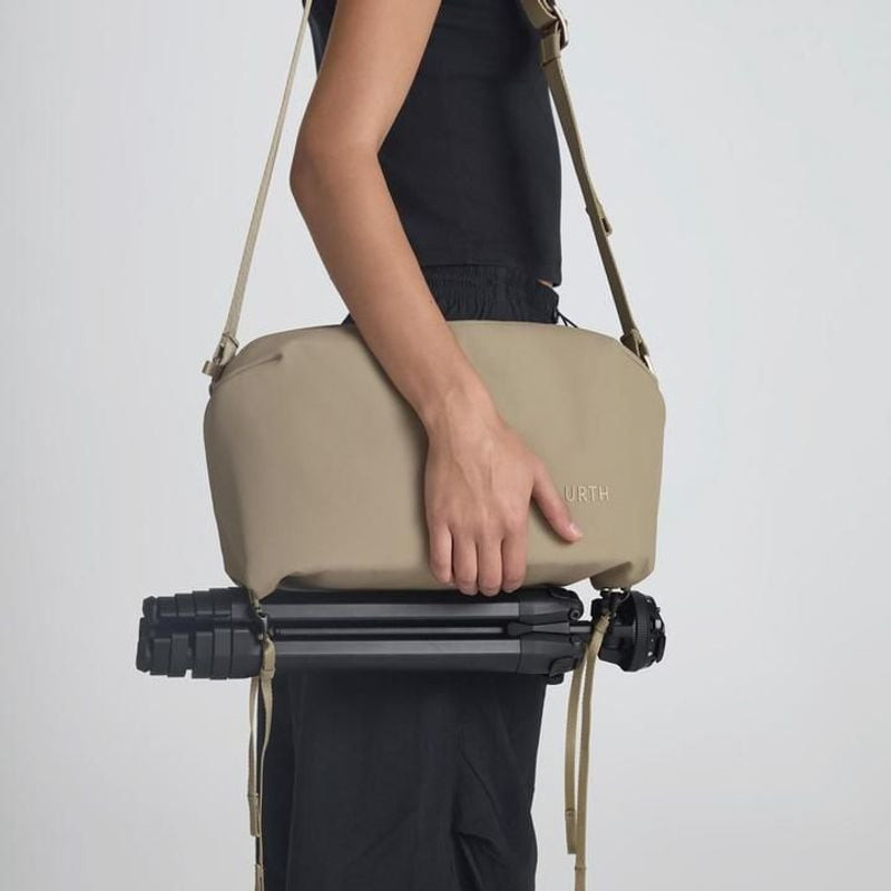 Photographe portant le sac bandoulière URTH DOLOMITE 8L CAMERA SLING BEIGE en ville avec appareil ph
