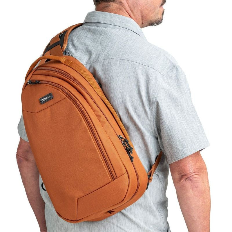 Photographe urbain portant le THINK TANK TURNSTYLE 11L URBAN RUST lors d’une sortie en ville