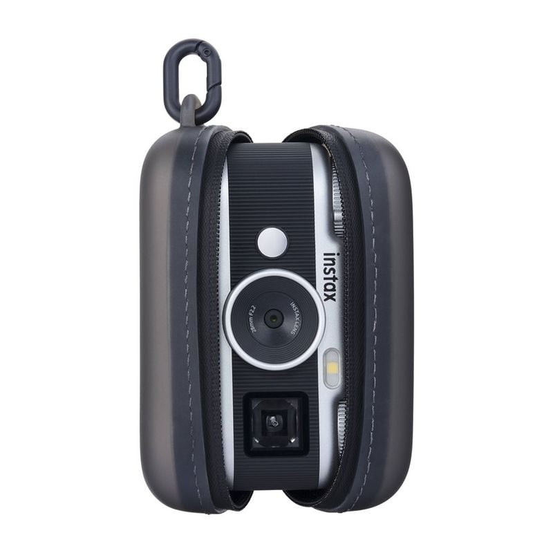 Appareil photo Instax Pal 2 debout dans sa housse de protection noire ouverte, objectif et logo inst